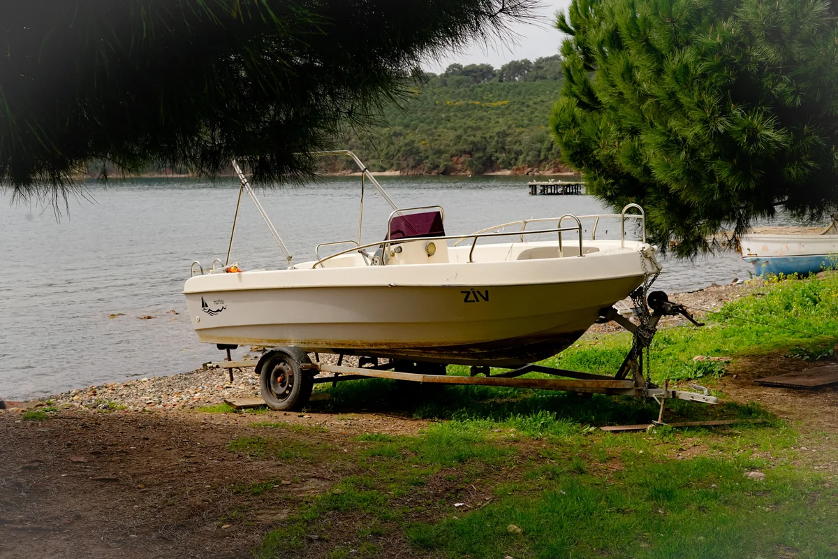 A boat on its trailer at the edge of a lake